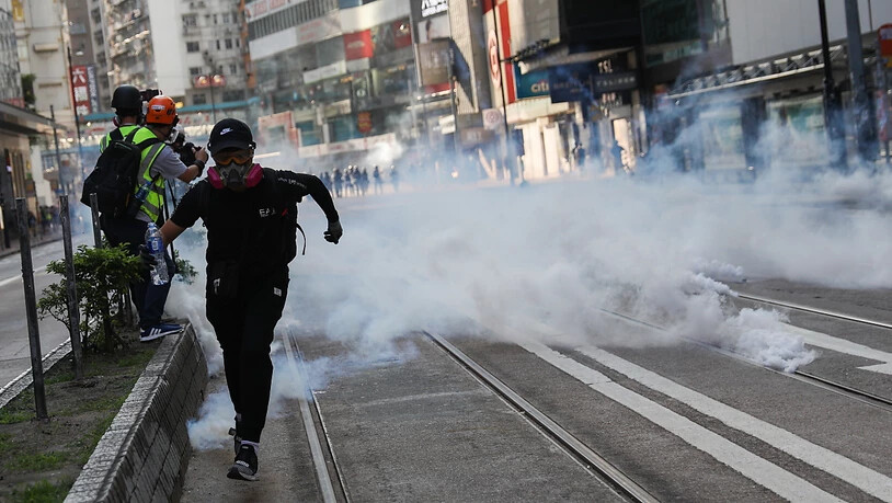 Nach dem Tränengas-Einsatz in Hongkong zerstreuten sich die Demonstranten, viele zogen in Richtung Stadtzentrum weiter, einige warfen mit Steinen.