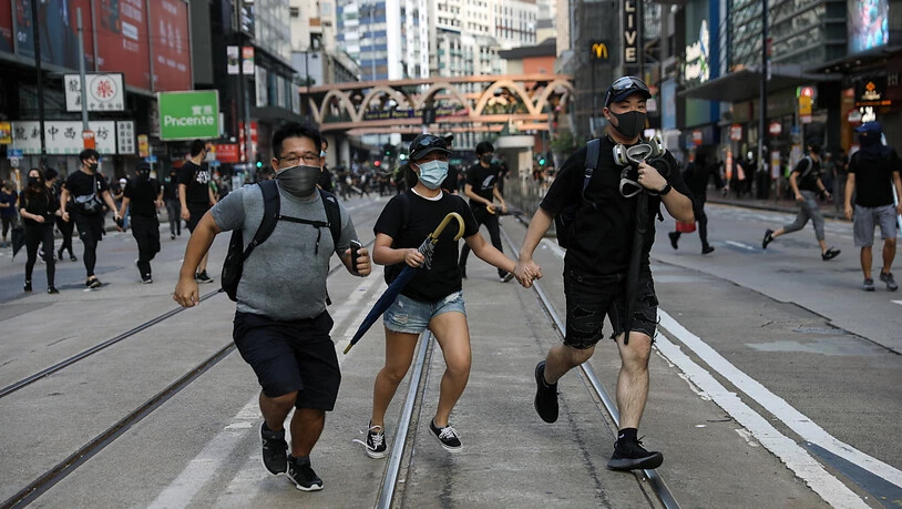 Demonstrierende in Hongkong flüchten vor Tränengas