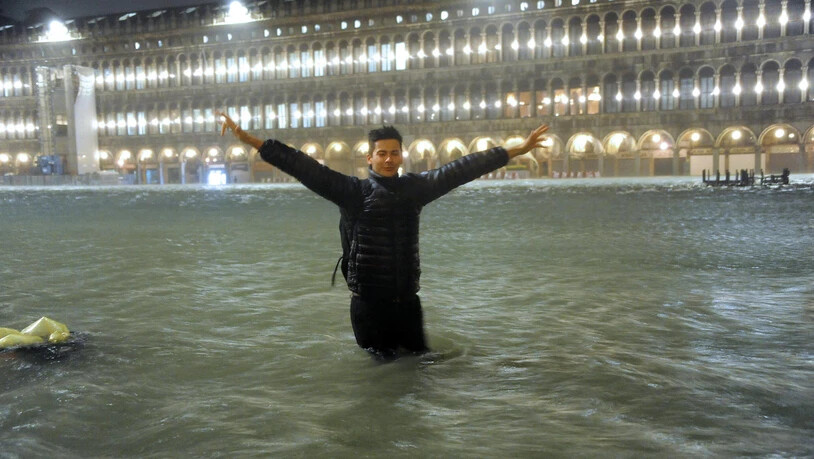 Ein Mann steht auf dem überfluteten Markusplatz in Venedig. (Archivbild)