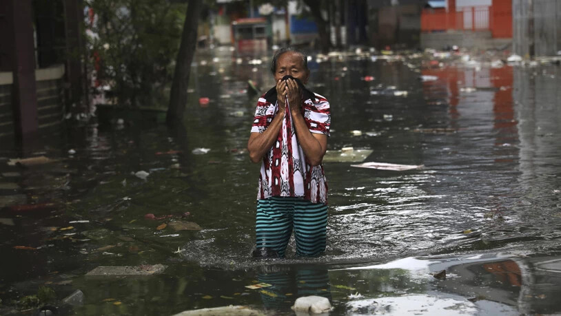 Eine Frau watet am Samstag durch das Wasser in Jakarta, Indonesien. Nach den schweren Überschwemmungen ist die Zahl der Toten auf mindestens 53 gestiegen.