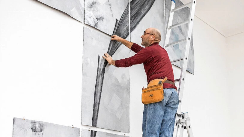 Fridolin Walcher hängt das Bild eines morschen Eisberges im Oberlichtsaal auf.