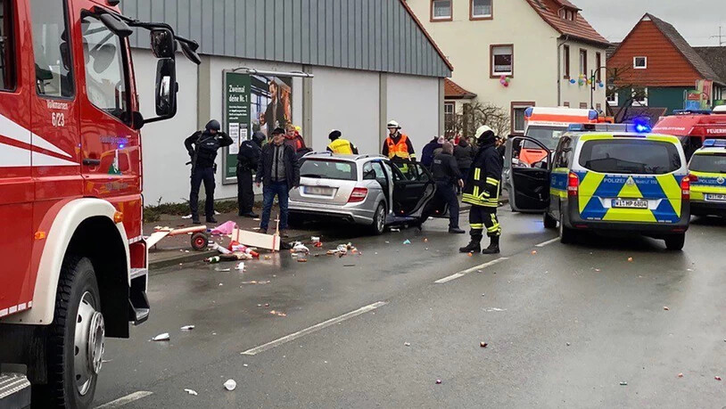 Rettungskräfte beim demolierten Auto  an der Unfallstelle im nordhessischen Volkmarsen, wo ein Autofahrer in einen Rosenmontagsumzug fuhr. Es gabe Dutzende Verletzte.