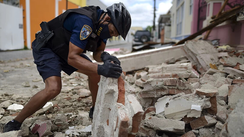 Ein Polizist untersucht Erdbebentrümmer in Ponce auf der Karibikinsel Puerto Rico.