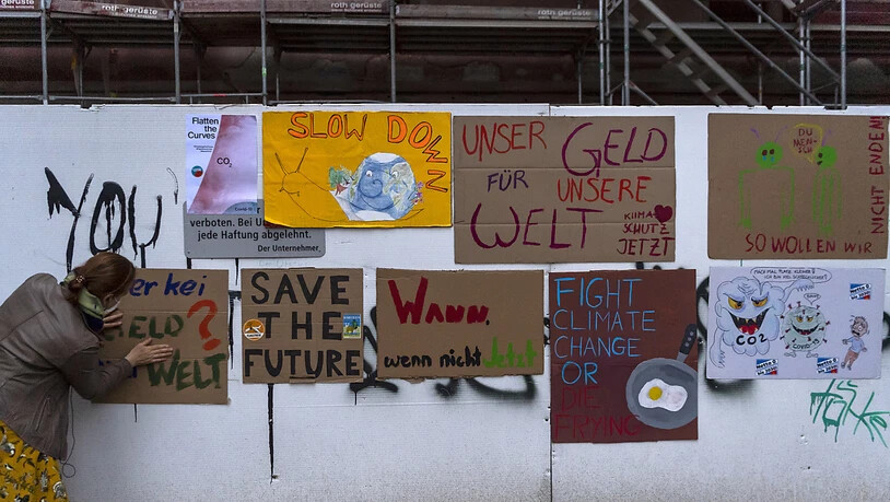 In Basel hängen Plakate von Klima-Aktivisten an einer Bauwand.