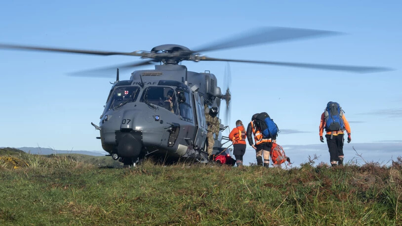 HANDOUT - Rettungshelfer gehen während eines Einsatzen an Board eines Hubschraubers. Zwei in der Wildnis Neuseelands vermisste Wanderer sind nach 18 Tagen lebend gefunden worden. Eine Helikopterbesatzung entdeckte am Mittwoch Rauchschwaden eines Feuers,…