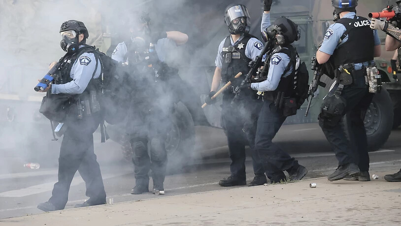 Polizisten versuchen in Minneapolis, die Proteste einzudämmen und die Ausgangssperre durchzusetzen.