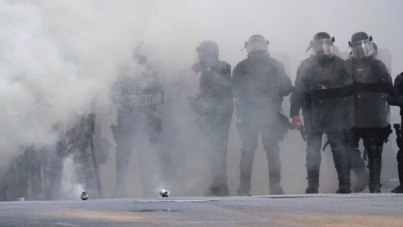 dpatopbilder - Polizisten stehen während eines Protests in Atlanta inmitten einer Tränengaswolke. Foto: Ben Gray/Atlanta Journal-Constitution/AP/dpa