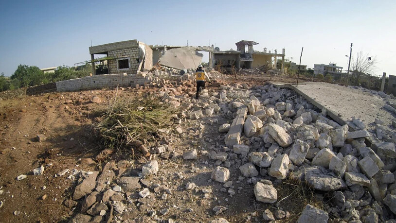 HANDOUT - Ein Mitglied des syrischen Zivilschutzes, bekannt als Weißhelm, steht inmitten von Trümmern von Häusern, die bei einem Luftangriff auf die Provinz Idlib zerstört wurden. Foto: Uncredited/Syrian Civil Defense White Helmets/AP/dpa - ACHTUNG: Nur…