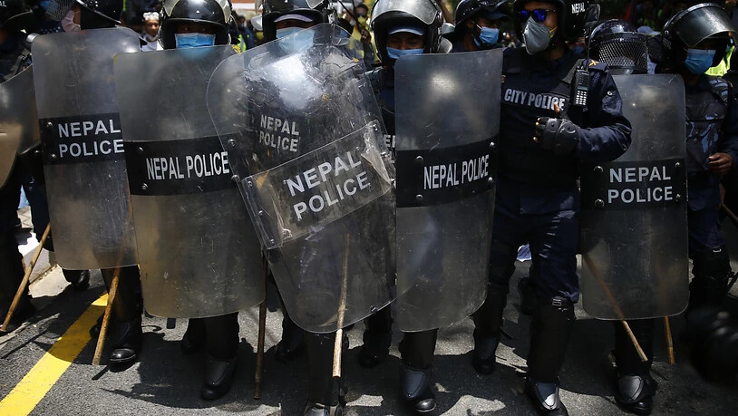 Polizisten stehen mit Mundschutz und Schutzschildern auf der Straße vor der Residenz des Premierministers. Hunderte Menschen haben dafür demonstriert, dass die Regierung die Maßnahmen aufgrund der Corona-Pandemie verstärkt und die Testzahlen erhöht. Foto…