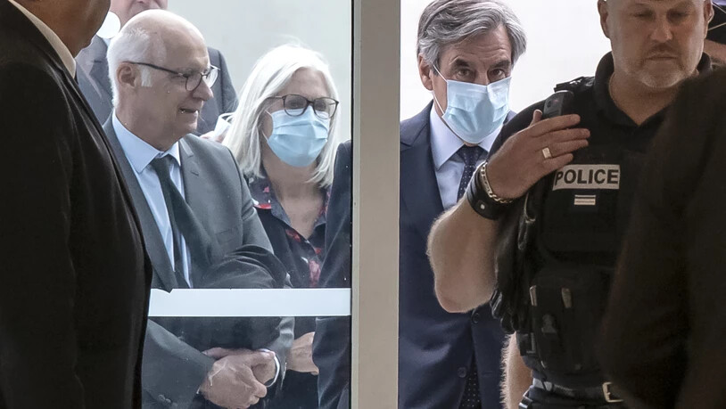 Francois Fillon (Mitte, r), ehemaliger Premierminister von Frankreich, und seine Frau Penelope (Mitte, l) beim Eintreffen im Gerichtsgebäude. Foto: Michel Euler/AP/dpa