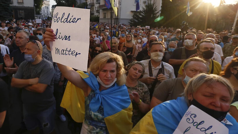 Demonstranten schwenken vor dem Büro des Präsidenten ukrainische Flaggen und halten Plakate mit der Aufschrift: «Soldier Lives Matter». Foto: Efrem Lukatsky/AP/dpa