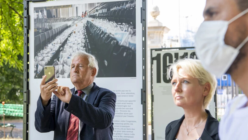Hans Stöckli (l.) und Isabelle Moret (Mitte) besuchen eine Fotoausstellung über die Nahrungsmittelverteilung an Bedürftige während der Corona-Krise in Genf.