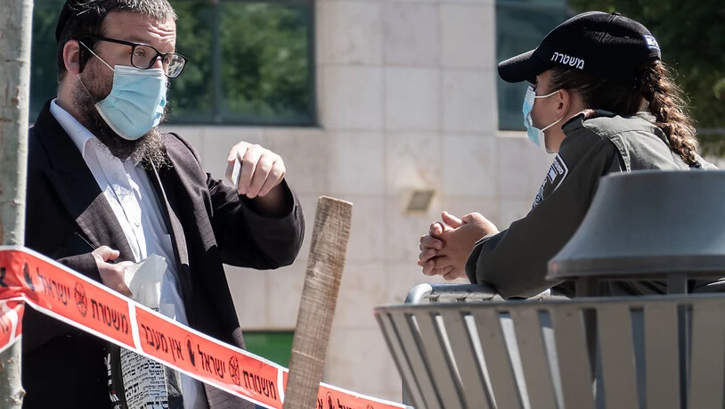 Eine Polizistin prüft den Ausweis eines jüdischen Anwohners in Jerusalem. Die israelische Regierung führt erneut Lockdown-Maßnahmen ein. Foto: Nir Alon/ZUMA Wire/dpa