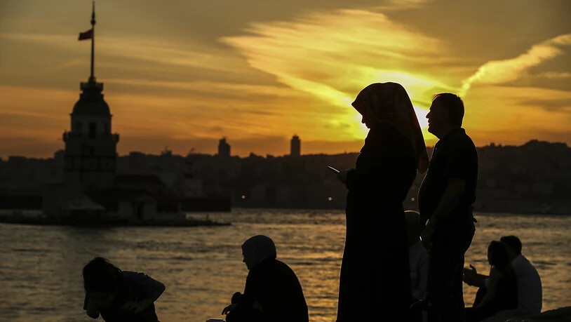 ARCHIV - Menschen stehen im Sonnenuntergang am Bosporus. (zu dpa "Kampf um Rollen und Regeln - Frauenmorde in der Türkei") Foto: Emrah Gurel/AP/dpa