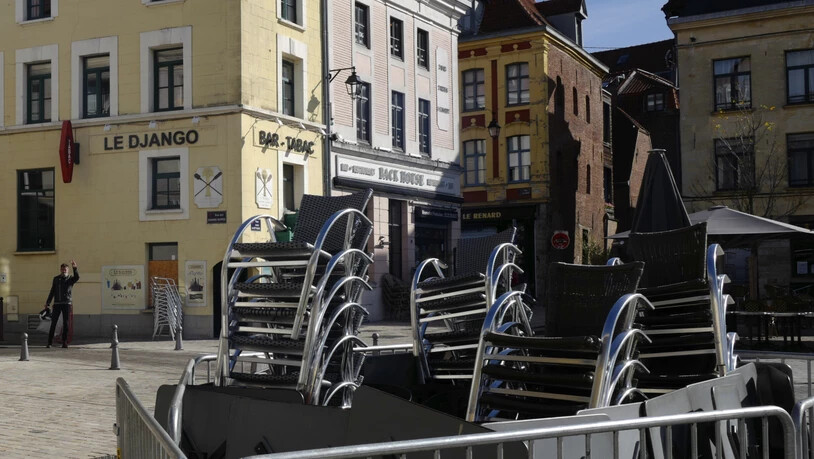Gestapelte Stühle vor einem Café in Lille. Foto: Michel Spingler/AP/dpa