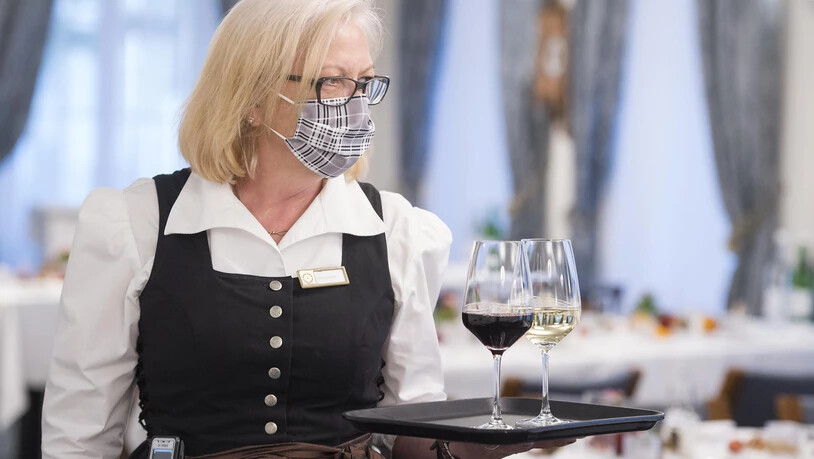 Eine Servicefachfrau im Hotel Stern in Chur serviert mit Schutzmaske.