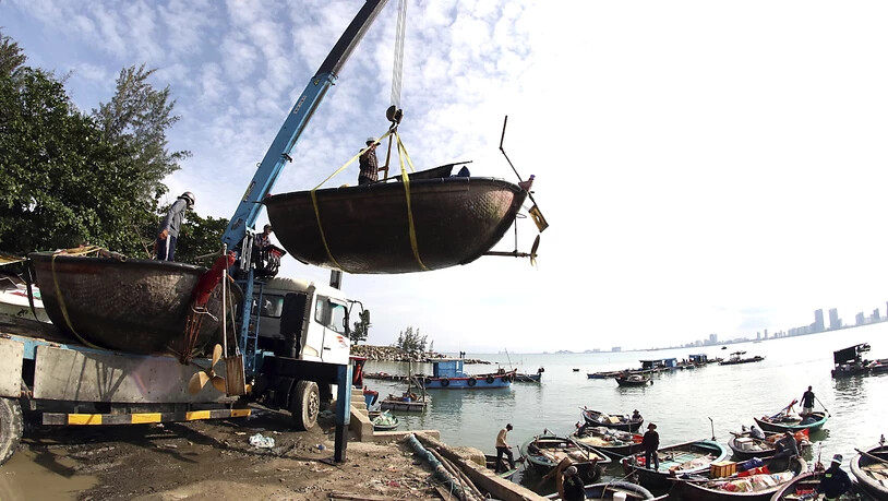 Menschen bewegen Fischerboote in Vorbereitung auf den Sturm Molave. In Vietnam bereiten sich die Behörden darauf vor, 1,2 Millionen Menschen vor einem neuen Tropensturm in Sicherheit zu bringen. Foto: Tran Le Lam/VNA/AP/dpa