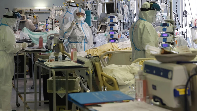 Medizinisches Personal in Schutzkleidung behandelt Patienten auf der Intensivstation des Krankenhaus San Filippo Neri. Foto: Alessandra Tarantino/AP/dpa