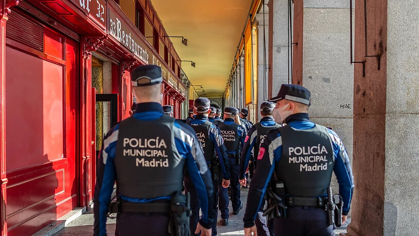 Eine Gruppe Polizisten mit Masken ist in der Stadmitte im Einsatz. Zur weiteren Eindämmung der Corona-Pandemie riegelt sich Madrid zwischen dem 4. und dem 13. Dezember ab. Foto: Diego Radamã©s/Zuma Press/dpa
