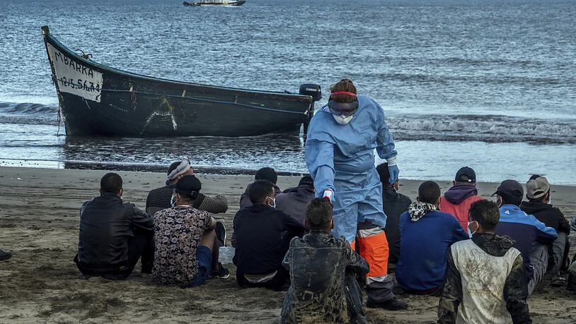 ARCHIV - Bei Migranten aus Marokko wird die Temperatur messen, nachdem sie mit einem Holzboot an der Küste von Gran Canaria angekommen sind. Foto: Javier Bauluz/AP/dpa