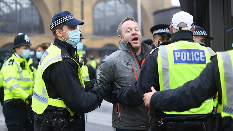Ein Mann wird während einer Demonstration von Polizisten weggeführt. Foto: Stefan Rousseau/PA Wire/dpa