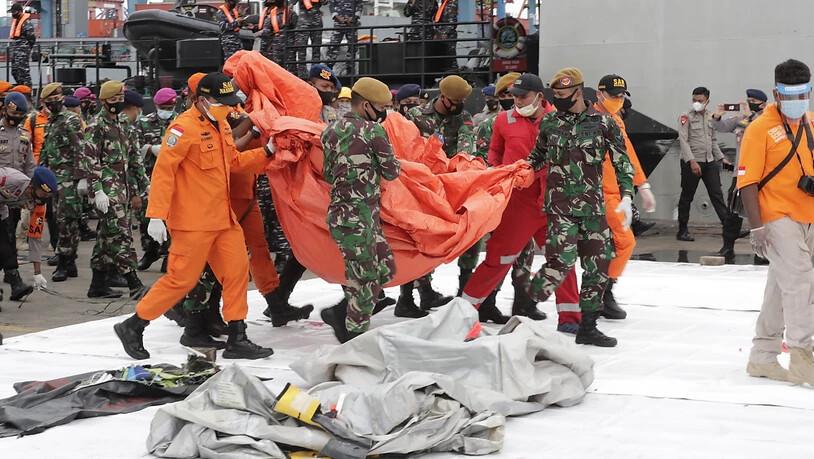 Indonesische Rettungskräfte bergen Leichenteile und Trümmer nach dem Absturz eines Passagierflugzeuges.