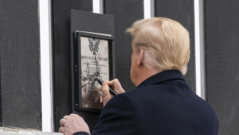 Donald Trump unterzeichnet eine Plakette an einem Abschnitt der US-Mexiko-Grenzmauer. Foto: Alex Brandon/AP/dpa