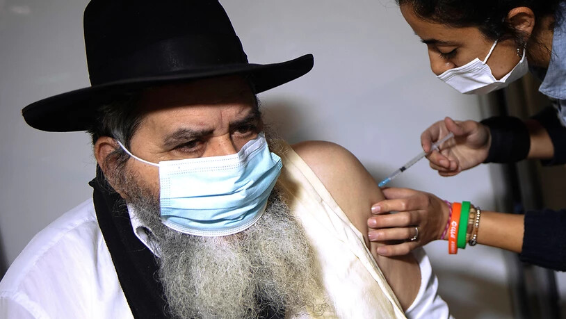 ARCHIV - Ein ultra-orthodoxer jüdischer Mann erhält von einer medizinischen Angestellten in einem Impfzentrum in Jerusalem eine Corona-Impfung. Foto: Oded Balilty/AP/dpa