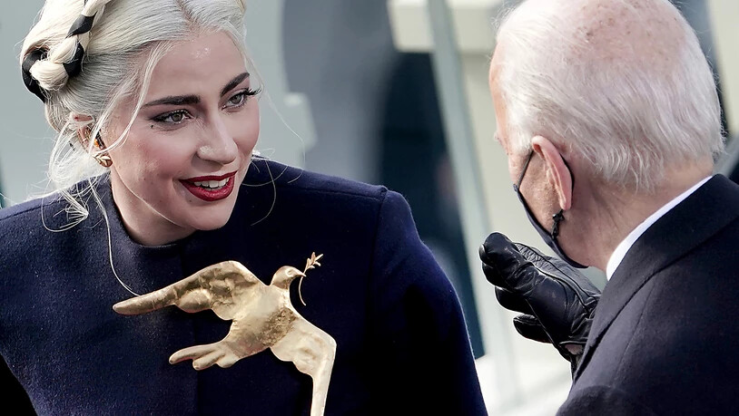 dpatopbilder - Lady Gaga mit goldener Friedenstaube  bei der Amtseinführung von Joe Biden im Kapitol. Foto: Greg Nash/AP/dpa