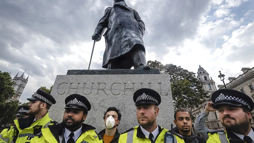 ARCHIV - Polizisten stehen um die Sir Winston Churchill-Statue auf dem Parliament Square während einer Kundgebung zum Gedenken an George Floyd. Foto: Kirsty Wigglesworth/AP/dpa