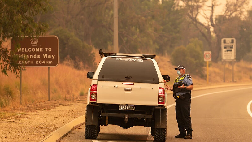 Police talk to residents hoping to return to their properties at a road block on Great Northern Highway in Perth, Tuesday, February 2, 2021. An out-of-control bushfire burning near the Perth Hills has engulfed at least three homes and is threatening more…