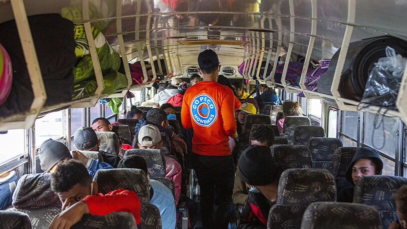 Ein honduranischer Regierungsmitarbeiter kontrolliert die Sitzplätze in einem Bus. Migranten versuchen regelmäßig über Honduras, Guatemala und El Salvador in die USA zu kommen. Foto: Oliver De Ros/AP/dpa