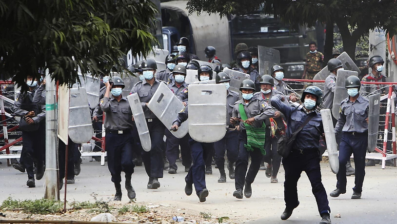 Polizisten stürmen auf Demonstranten in Mandalay zu, um sie zu vertreiben. Foto: --/AP/dpa
