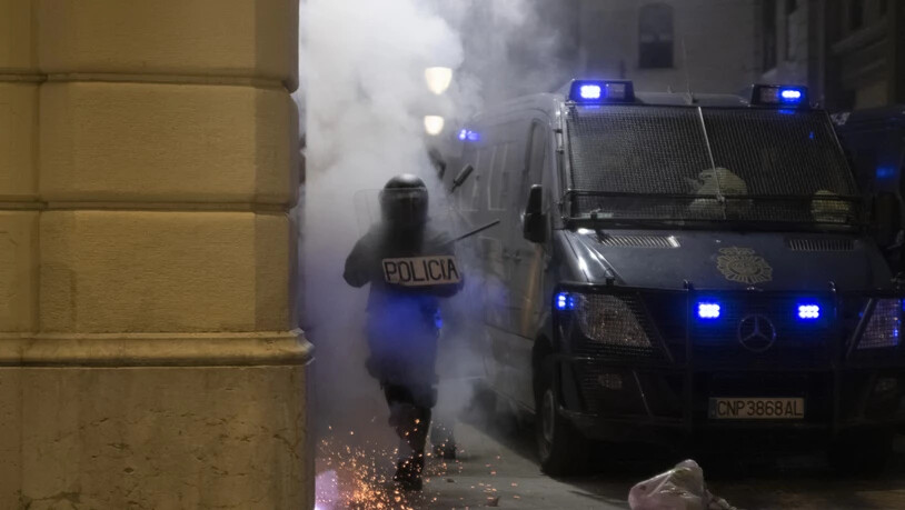 Ein Polizist läuft bei Ausschreitungen wegen der Inhaftierung des Rappers Hasél durch Rauch.  Am Wochenende gab es wieder jede Nacht Ausschreitungen. Foto: Lorena Sopêna I Lòpez/EUROPA PRESS/dpa