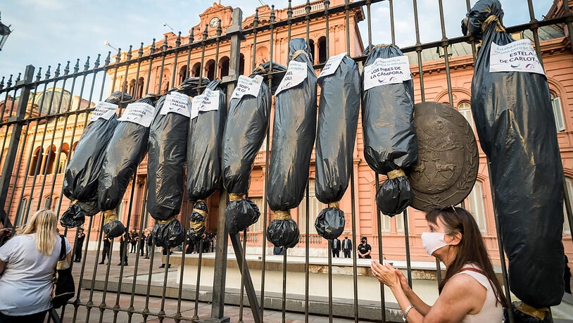 Schwarze Säcke, die an Leichensäcke erinnern, hängen bei einem Protest vor der Casa Rosada, dem Palast des Präsidenten von Argentinien. Foto: Alejo Manuel Avila/SOPA Images via ZUMA Wire/dpa