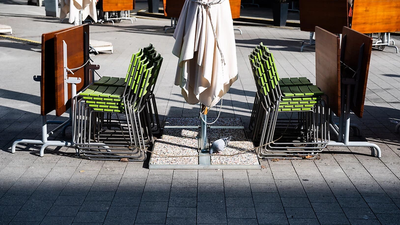 Gestapelte Stühle und zusammengeklappte Tische stehen in der Außengastronomie eines geschlossenen Restaurants in der Hannoveraner Innenstadt. Foto: Julian Stratenschulte/dpa