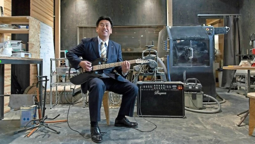 Bürgermeister von Onagawa: Beim Besuch einer neu angesiedelten Gitarrenmanufaktur spielt Yoshinki Suda ein Stück der Schweizer Rockband«Gotthard»; er ist in seiner Freizeit Gitarrist einer lokalen Heavy-Metal-Band.