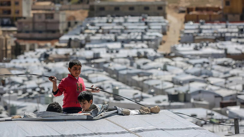 ARCHIV - Syrische Jungen spielen auf dem Dach einer Unterkunft im Flüchtlingslager Barra nordöstlich der libanesischen Hauptstadt Beirut. Foto: Marwan Naamani/dpa