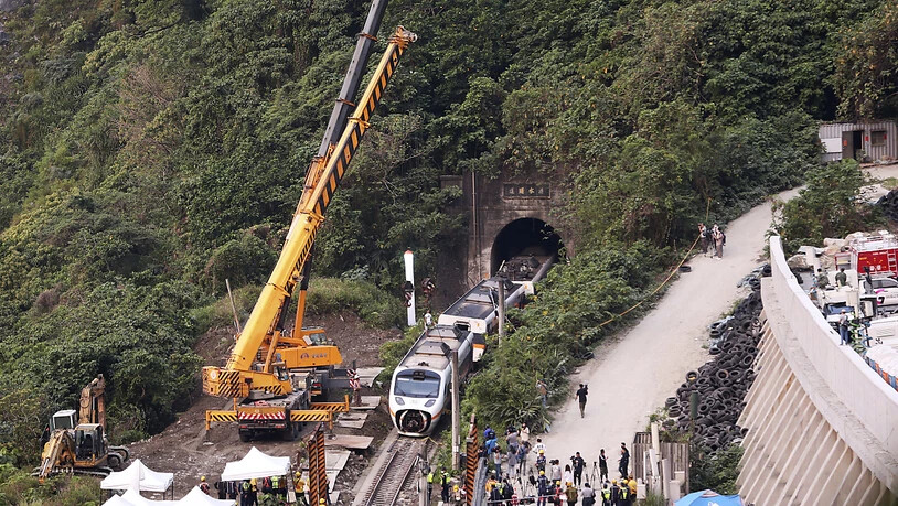Rettungskräfte entfernen ein Teil eines entgleisten Zuges. Bei einem schweren Zugunglück in Taiwan sind am 02.04.2021 mindestens 51 Menschen ums Leben gekommen. Foto: Chiang Ying-Ying/AP/dpa