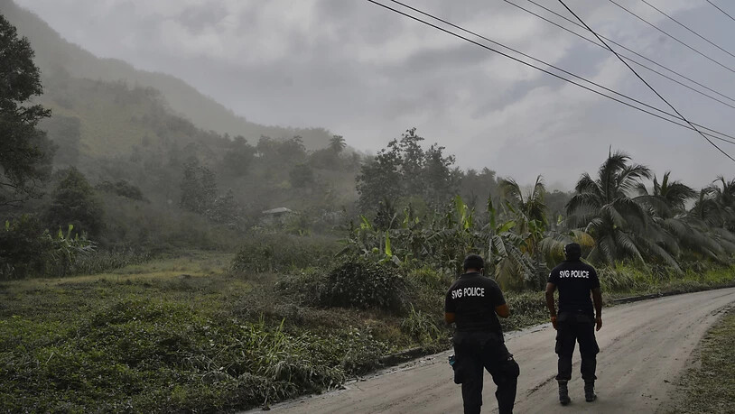 Polizisten patrouillieren nach dem Ausbruch des Vulkans La Soufrière auf einer aschebedeckten Straße, um Menschen davon abzuhalten, sich dem aktiven Vulkan zu nähern. Foto: Orvil Samuel/AP/dpa