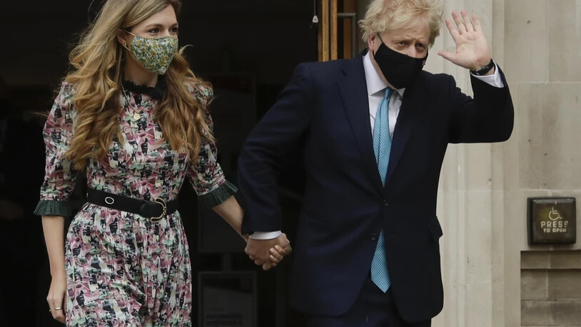 dpatopbilder - Boris Johnson (r), Premierminister von Großbritannien, winkt, als er mit seiner Verlobten Carrie Symonds nach ihrer Stimmenabgabe das Methodist Central Hall verlässt. Foto: Matt Dunham/AP/dpa