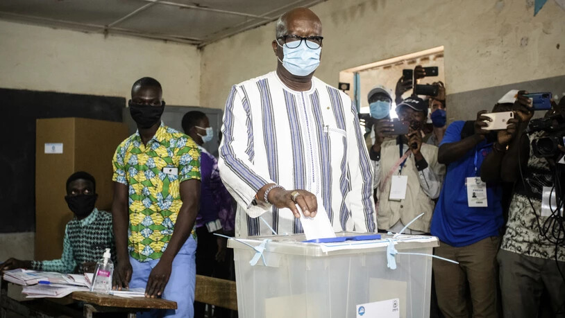 ARCHIV - Burkina Fasos Präsident Roch Kabore gibt seinen Stimmzettel bei den Präsidentschaftswahlen im November letzten Jahres ab. Nachdem mehr als 100 Menschen bei einem bewaffneten Überfall getötet wurden, hat er eine dreitägige Staatstrauer angeordnet…