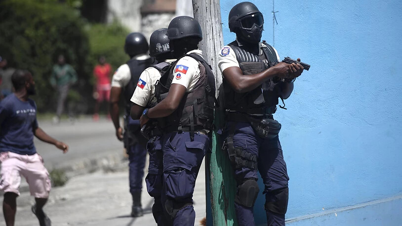 Polizisten mit gezogenen Waffen suchen in Port-au-Prince nach Verdächtigen im Mordfall des haitianischen Präsidenten Jovenel Moise. Foto: Joseph Odelyn/AP/dpa