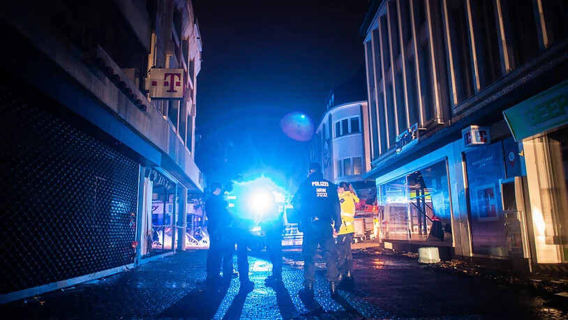 Polizisten gehen durch die zerstörte Innenstadt von Kirchheim in Nordrhein-Westfalen, um Plünderungen zu verhindern. Hier hatten heftige Regenfälle in der Nacht für Schlammlawinen und Überflutungen gesorgt. Kanzlerin Merkel hat den Betroffenen der…