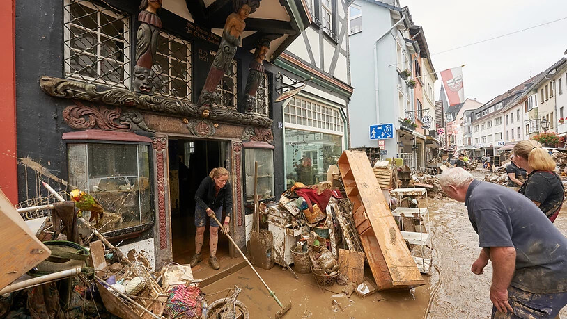 Anwohner und Ladeninhaber in Ahrweiler versuchen, ihre Häuser vom Schlamm zu befreien und unbrauchbares Mobiliar nach draußen zu bringen. Während in vielen Flutgebieten  die Aufräumarbeiten beginnen, wird in den Trümmern der Katastrophengebiete weiterhin…