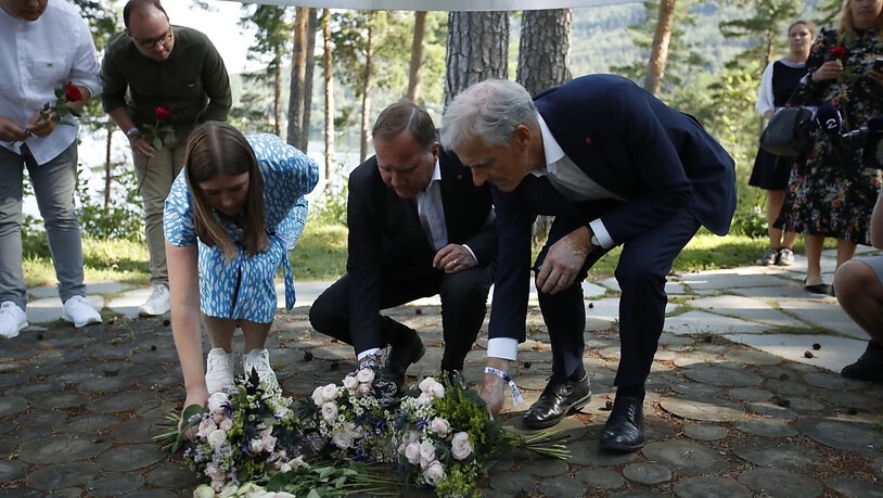 Astrid Hoem, Vorsitzende der AUF,  Stefan Löfven, Ministerpräsident von Schweden, und Jonas Gahr Støre, Vorsitzender der norwegischen Arbeiterpartei, legen Blumen nieder. Foto: Beate Oma Dahle/NTB/dpa