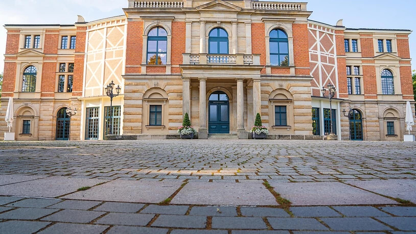 Wolken ziehen über das Bayreuther Festspielhaus. Am 25.07.2021 beginnen die Bayreuther Festspiele. Foto: Nicolas Armer/dpa