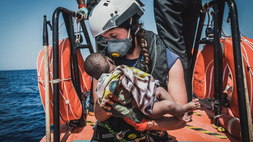 dpatopbilder - HANDOUT - Die Helferin eines Teams des Rettungsschiffes "Ocean Viking" hält ein Kind in den Armen, das zuvor aus einem überfüllten Boot gerettet wurde. Foto: Flavio Gasperini/SOS Mediterranee/dpa - ACHTUNG: Nur zur redaktionellen…