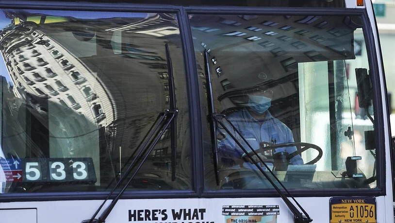 ARCHIV - Ein Busfahrer mit Mund-Nasen-Schutz fährt durch die Stadt.  Nach dem medizinischen Personal und den städtischen Mitarbeitern müssen in New York ab Anfang September 2021 auch alle Mitarbeiter der Verkehrsbetriebe entweder einen Impfnachweis…