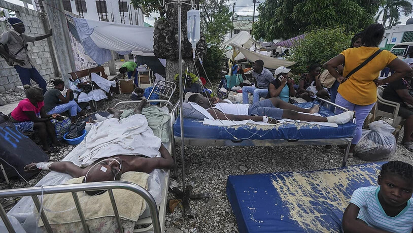 Zwei Tage nach einem Erdbeben der Stärke 7,2 in Haiti liegen Verletzte vor dem Krankenhaus Immaculée Conception in Les Cayes im Südwesten des Landes. Nach Angaben der Zivilschutzbehörde Haitis ist die Zahl der Todesopfer auf 1419 gestiegen. Rund 6900…